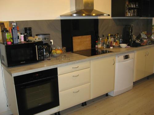 une cuisine avec un micro-ondes et une cuisinière four supérieur dans l'établissement Loft 200m2 14 couchages tout près du port, à La Ciotat