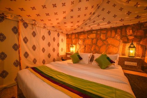 a bedroom with a bed in a tent at The Carvaans Resort-Luxury Desert Camp Jaisalmer in Jaisalmer