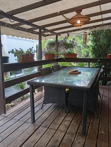 une table et des chaises sur une terrasse avec pergola dans l'établissement Au rocher de Pascal lit mezzanine, à Montalivet-les-Bains