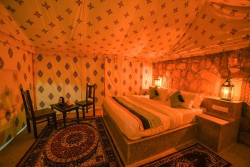 a bedroom with a bed in a tent at The Carvaans Resort-Luxury Desert Camp Jaisalmer in Jaisalmer