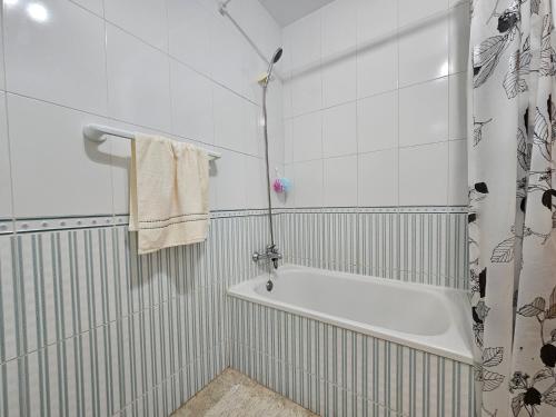 Un baño blanco con bañera y ducha. en Cozy apartment beach 300 metros, en Santa Pola