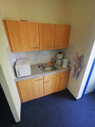 a small kitchen with a sink and a microwave at Pilotenunterkunft Fliegerhorst in Strausberg