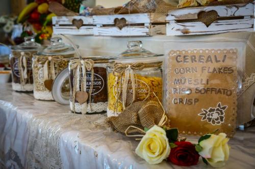 a table with jars of food and flowers on it at Hotel Florida in Levico Terme