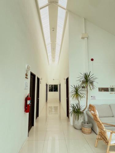 a hallway with a couch and plants in a building at LAIWAII HOME in Hat Yai