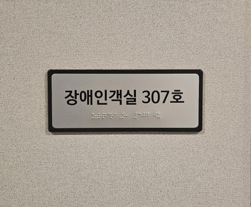 a sign on a wall with a clock on it at The Western Busan Hotel By STAYNEO in Busan