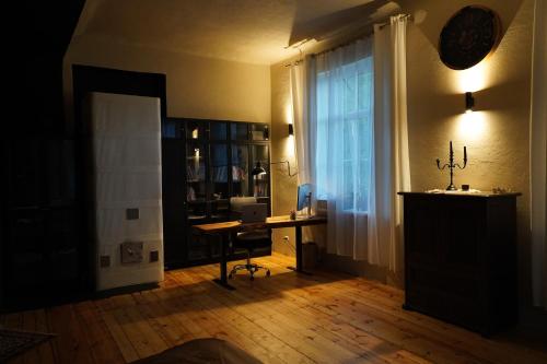 a room with a desk with a computer and a window at Meirānu muiža in Meirāni