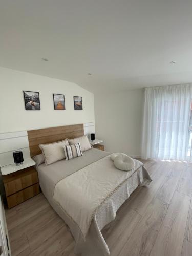 Un dormitorio blanco con una cama grande y una ventana. en Hogar Ribeiriña Ribeira, en Ribeira