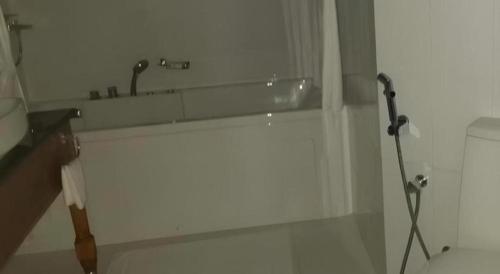 a white bathroom with a shower and a bath tub at Naaval Hotel in Batticaloa
