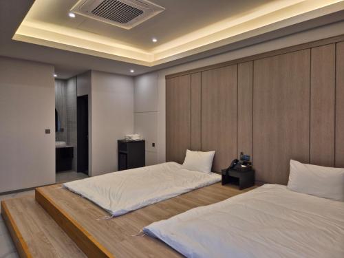 a bedroom with two beds and a headboard at The Western Busan Hotel By STAYNEO in Busan