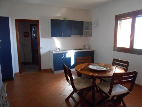 een keuken met een houten tafel en een tafel met stoelen bij Villino Caddu in San Teodoro