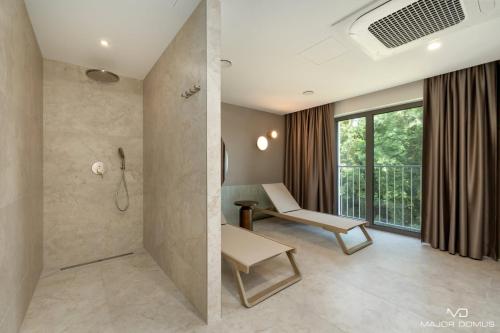 a bathroom with a shower and a desk and a chair at Sand Dunes Blue Marine by Major Domus Club in Dziwnów