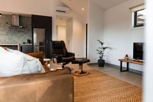 a living room with a couch and a chair at Villa 3 - Greenstone Villas in St Helens