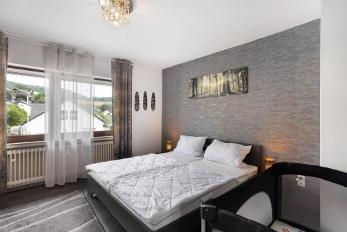 a bedroom with a bed and a large window at Ferienwohnung Zum Hasen in Meschede