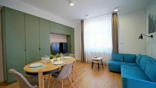 a living room with a table and a blue couch at Apartamenty EverySky Kowary, Blue z windą in Kowary