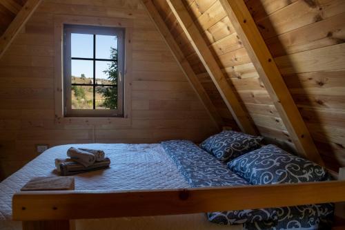 Ce lit se trouve dans une chambre en bois dotée d'une fenêtre. dans l'établissement Wolf Apex, à Žabljak