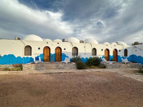 a building with a bunch of chairs in front of it at Dolphin Camp in Dahab