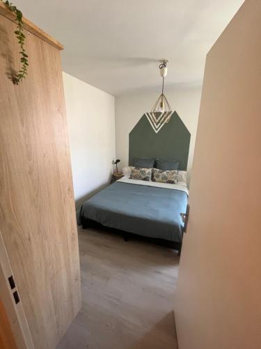 a bedroom with a bed with a green headboard at Apt central entre stade de France et villette in Aubervilliers