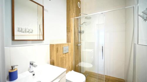 a bathroom with a shower and a toilet and a sink at Apartamenty EverySky Kowary, Blue z windą in Kowary