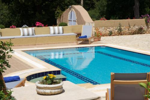 a swimming pool with two chairs next to it at Villa Emily in Fiskardho