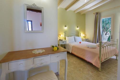a bedroom with a bed and a desk and a mirror at Villa Emily in Fiskardho