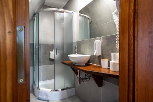 een badkamer met een wastafel en een glazen douche bij Pokoje Gościnne u Bronka in Ciche Małe