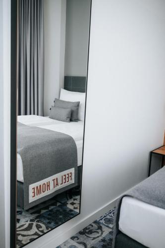 a mirror in a room with a bed and a bed sqor at Coffee Fellows Hotel Trier in Trier