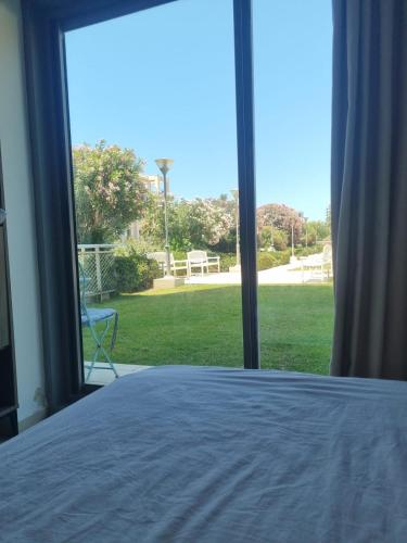 a bedroom with a bed and a view of a yard at אוקיינוס במרינה הרצליה פיתוח in Herzliyya B