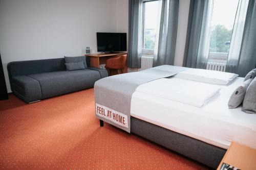 a hotel room with a bed and a couch at Coffee Fellows Hotel Trier in Trier