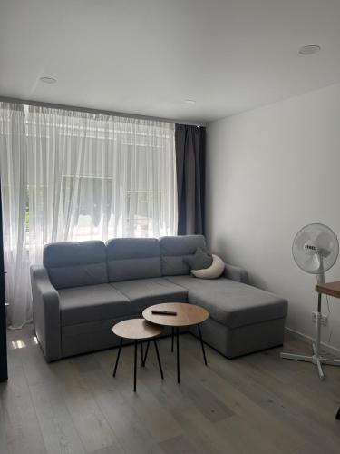 a living room with a blue couch and a table at AB Apartment in Marijampolė
