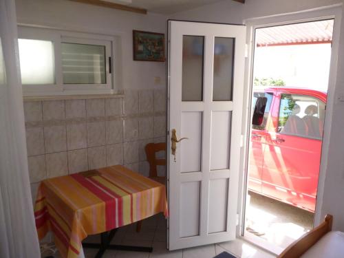 a door to a room with a table and a car at Studio Apartman Mira in Neum