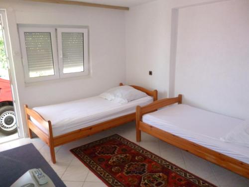 two beds in a small room with a rug at Studio Apartman Mira in Neum