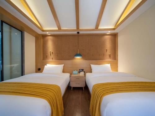 two beds sitting next to each other in a room at Lijiang MuYa Chinese Courtyard Hotel with Water View in Lijiang