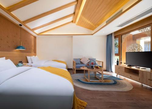 a bedroom with a large bed and a tv at Lijiang MuYa Chinese Courtyard Hotel with Water View in Lijiang