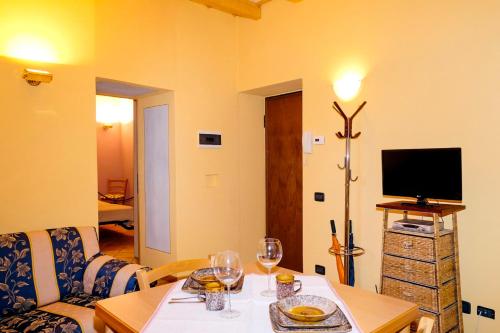 a living room with a couch and a table with wine glasses at Casa Aurora in Cannobio