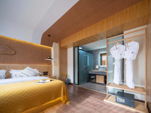 a hotel room with a bed and a bathroom at Lijiang MuYa Chinese Courtyard Hotel with Water View in Lijiang
