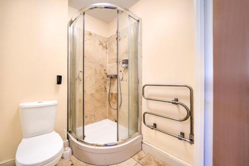 a shower stall in a bathroom with a toilet at GO2 Gloucester Hotel by OYO in Gloucester