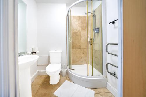 a bathroom with a shower and a toilet and a sink at GO2 Gloucester Hotel by OYO in Gloucester