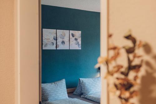 a room with a blue wall with four pictures at Wirie-Lodge in Diemtigen Ferienwohnung am Wiriehorn in Diemtigen