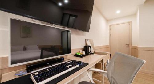 a room with a desk with a keyboard and a bed at Seven Motel Ansan in Ansan
