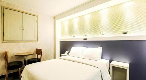 a bedroom with a bed and a table and a mirror at Seven Motel Ansan in Ansan