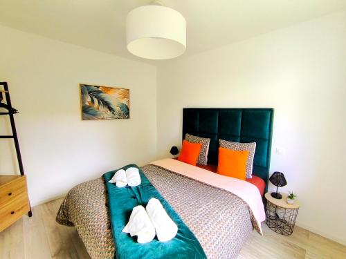 a bedroom with a bed with white shoes on it at Les Rochers - Raffinement boisé & Plage à 5 min en voiture - Sérénité in Brétigny