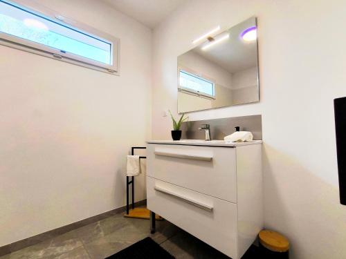 a bathroom with a sink and a mirror at Les Rochers - Raffinement boisé & Plage à 5 min en voiture - Sérénité in Brétigny
