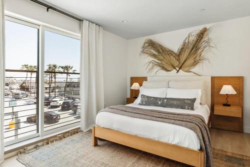 ein Schlafzimmer mit einem Bett und einem großen Fenster in der Unterkunft Tide House - Unit D - Modern Oceanview 1BD w Parking in El Segundo