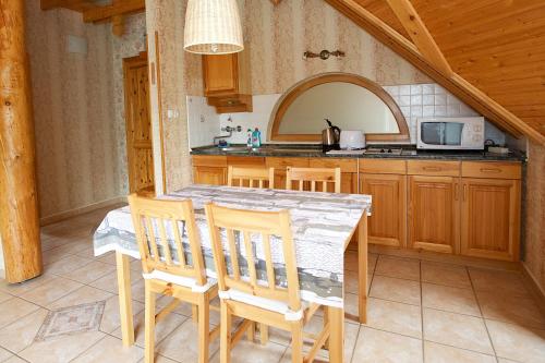 a kitchen with a table and chairs in a room at Harmónia Apartmanház in Hajdúszoboszló