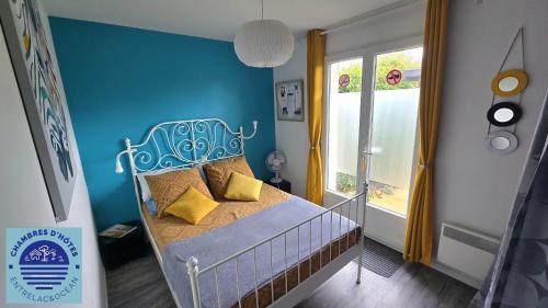 a blue bedroom with a bed with yellow pillows at EntreLac&Océan1 - chambre d'hôtes chez l'habitant, Entrée et terrasse privée- cyclotouristes bienvenue in Aureilhan