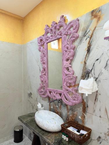 a bathroom with a pink mirror and a sink at Satoria Villa in Jaipur