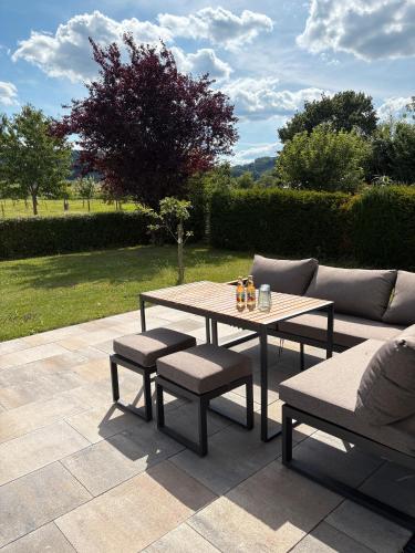 a table and chairs and a couch on a patio at Auszeit am Wiehengebirge in Bad Essen