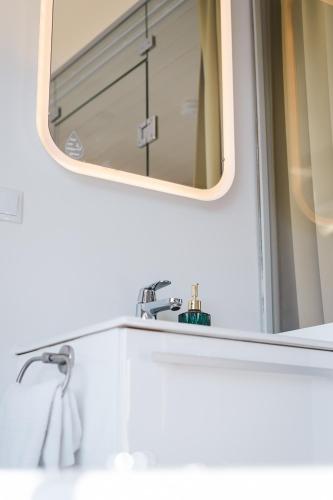 a bathroom with a mirror and a sink at Lieblingsplatz Parey - Ferienhaus am See in Parey