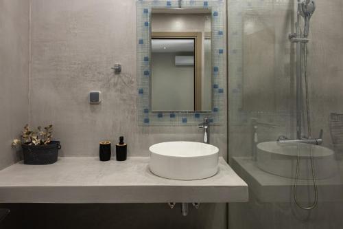 a white bathroom with a sink and a shower at Olea Apartments in Razáta