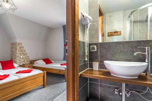 マウェ・チヘにあるApartament z widokiem na góry u Bronkaの洗面台付きのバスルームとベッドが2つある寝室